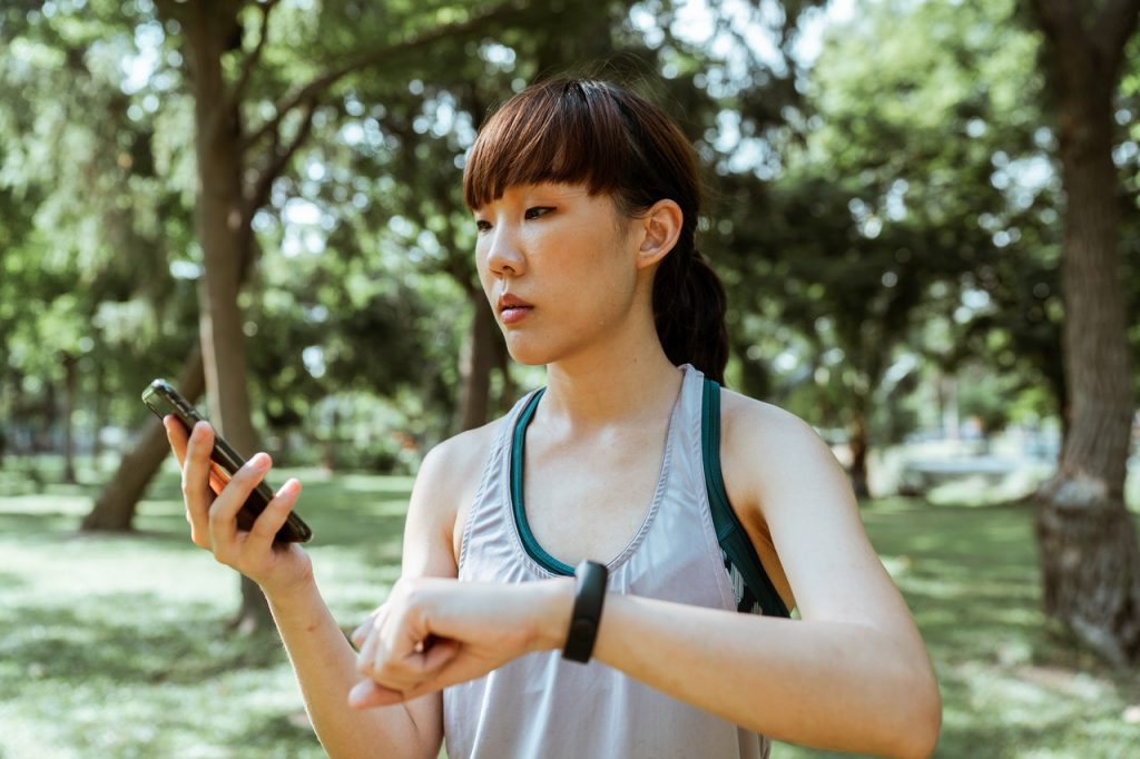 person checking info/vitals on phone and smartwatch